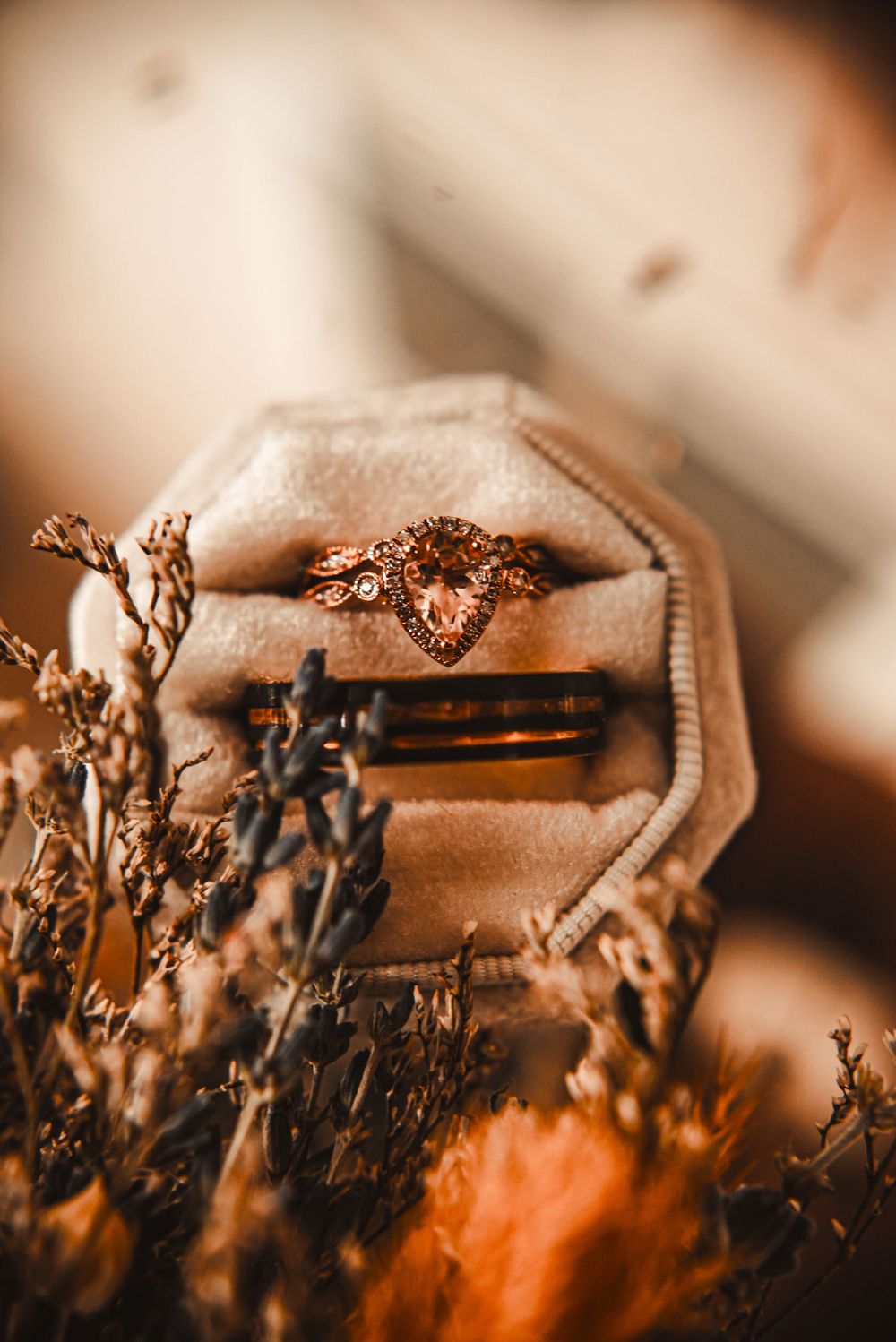 Elegant wedding ring displayed in velvet ring box with dried florals.
