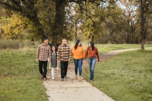 Group walking together on a path through an autumn park setting.