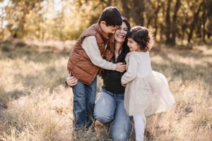 A warm family moment captured outdoors in golden natural lighting.