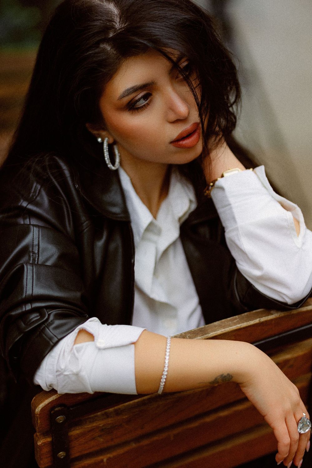 Artistic close-up shot of someone wearing pearls and a white collared shirt.