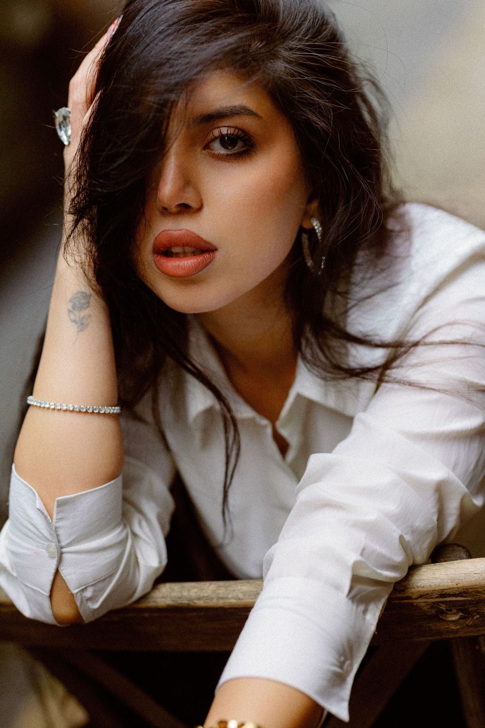 Artistic portrait series showing a woman in a white shirt with dark hair and red lipstick in moody lighting.
