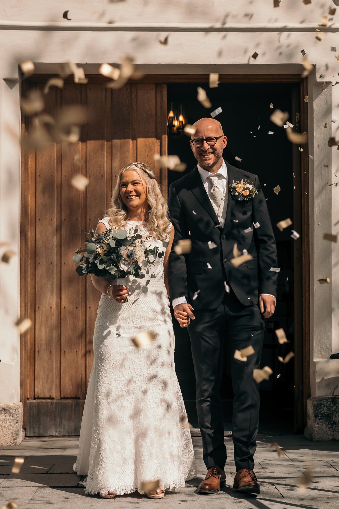 Brudpar som kommer ut från kyrkportarna och gratuleras med konfetti.