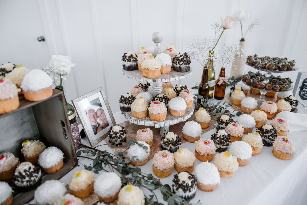 Artfully arranged dessert display with white frosted treats and greenery accents.