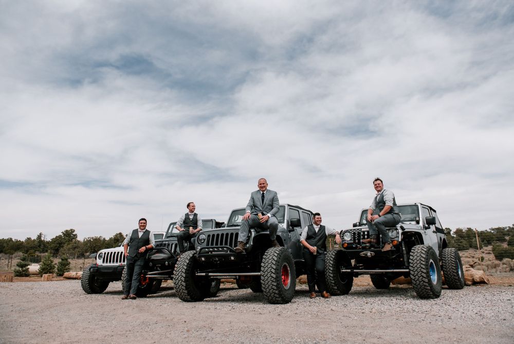 Row of Jeep vehicles parked in a desert landscape under cloudy skies.