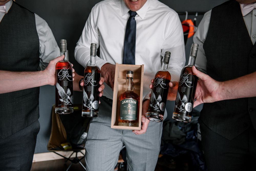 Vintage cameras being held and displayed against dark formal attire.