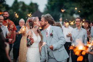 Romantic evening wedding celebration with sparklers creating magical light effects.