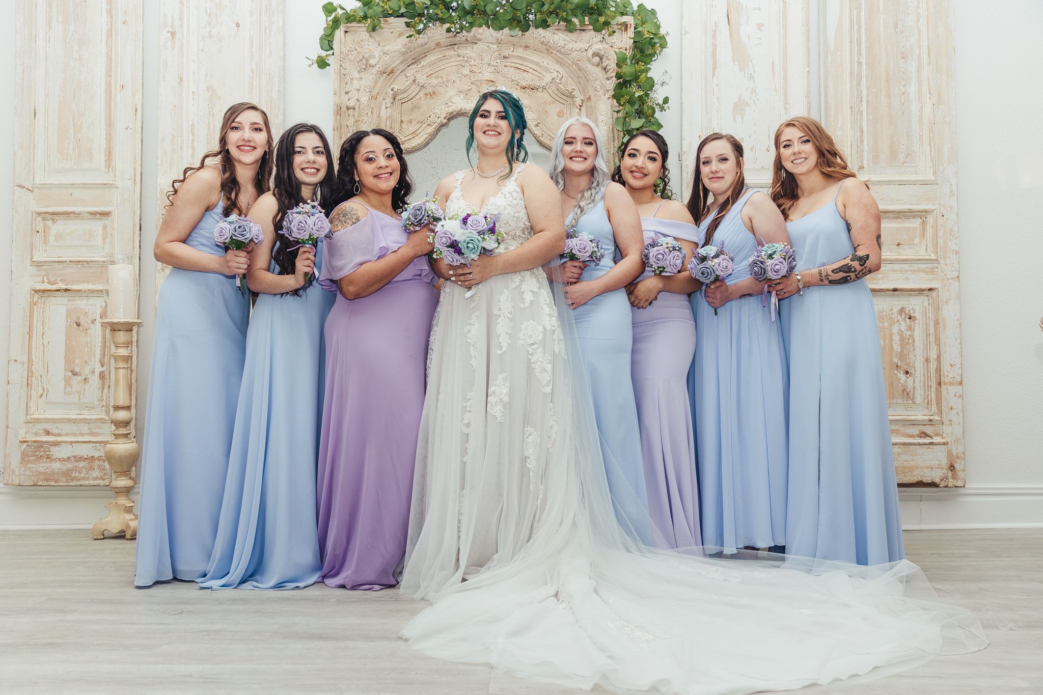 Bridesmaids in lavender dresses pose together during an elegant outdoor wedding.