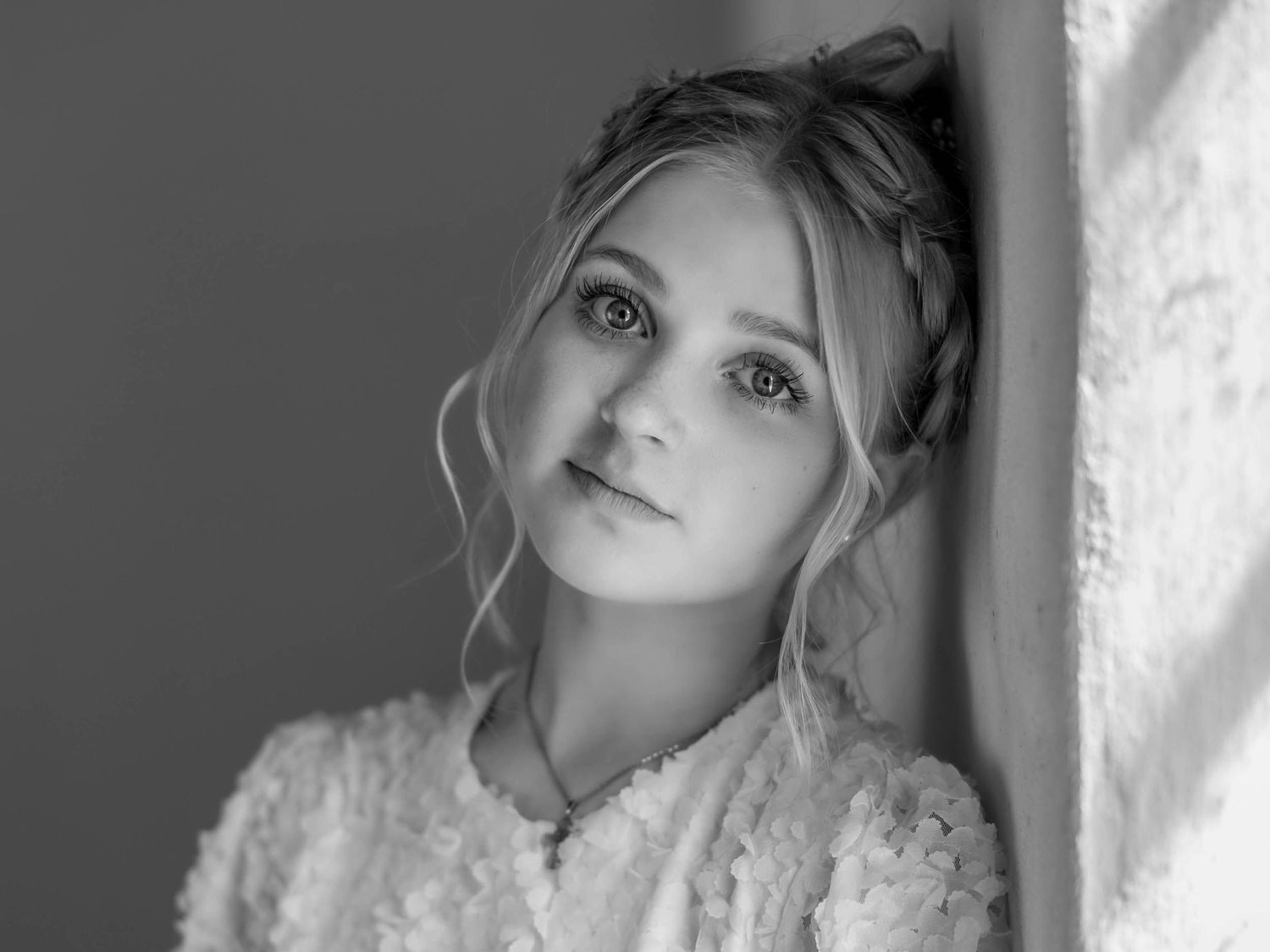 Artistic black and white portrait with soft natural window lighting.