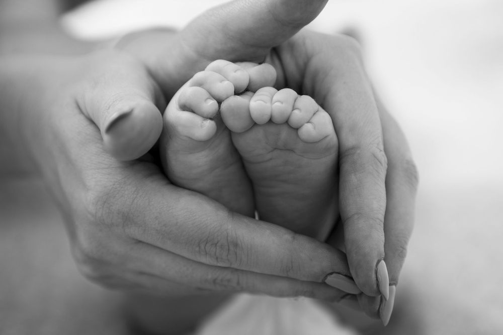 Newborn feet in Mum's hands.