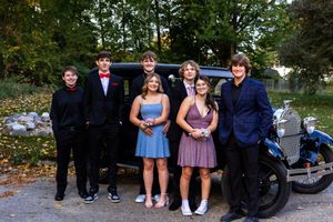 A group photo series showing friends in formal attire posing together near a car.