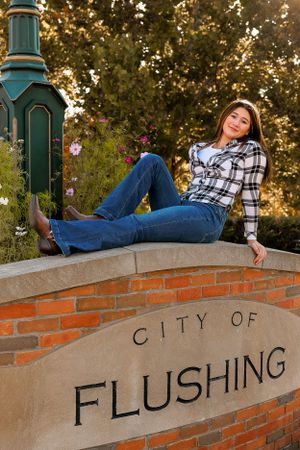 Person lounges on brick wall with text during golden hour sunset.