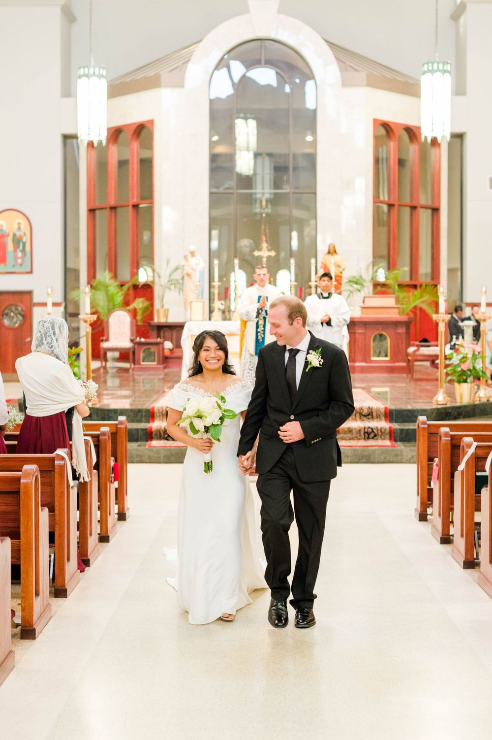 Catholic Wedding Photography at St. Monica Catholic Church, Edmond OK. Bride and groom walk down aisle.