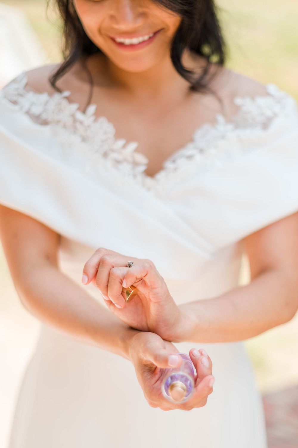 Bride puts on perfume ahead of her catholic wedding at St. Monica Catholic Church in Edmond, OK.