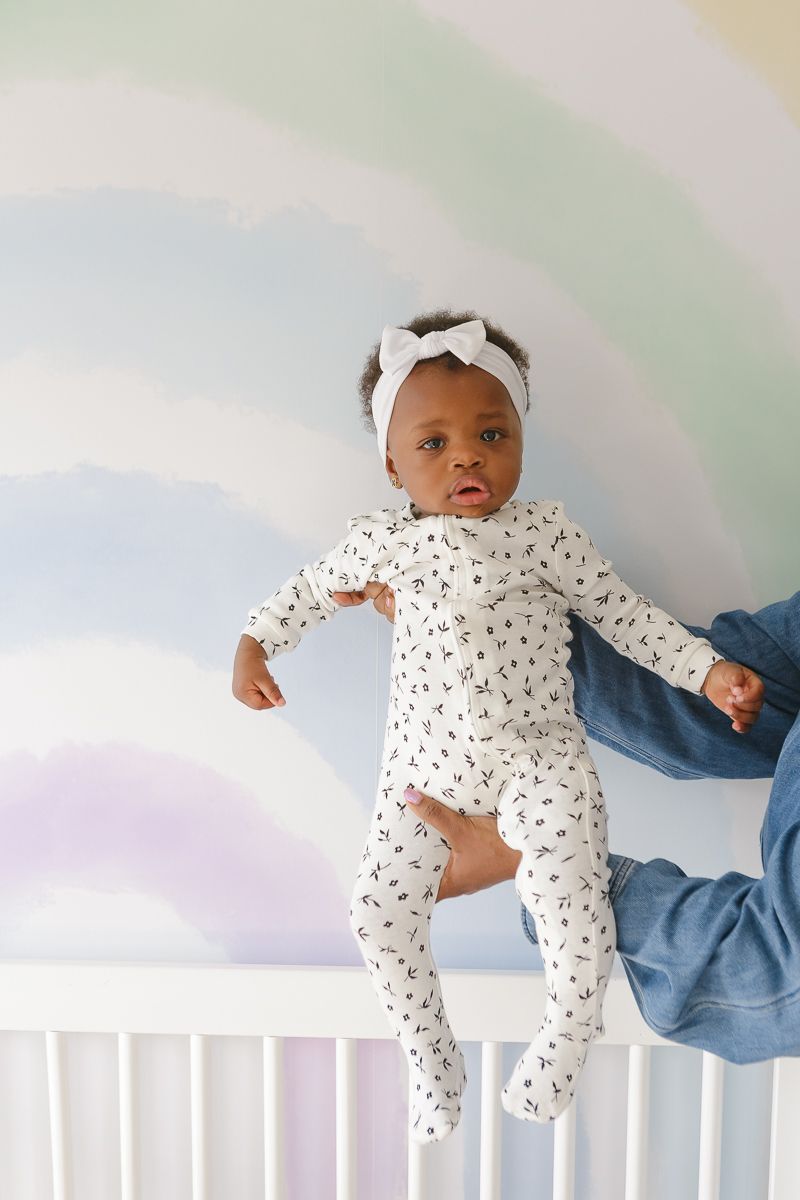 Birthday girl held against rainbow wall by NYC family photographer Paula Ortiz