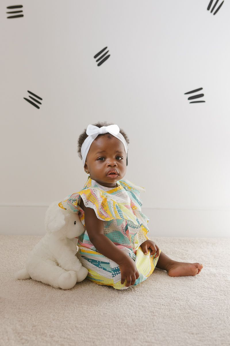 Birthday girl sitting next to stuffed animal by NYC family photographer Paula Ortiz