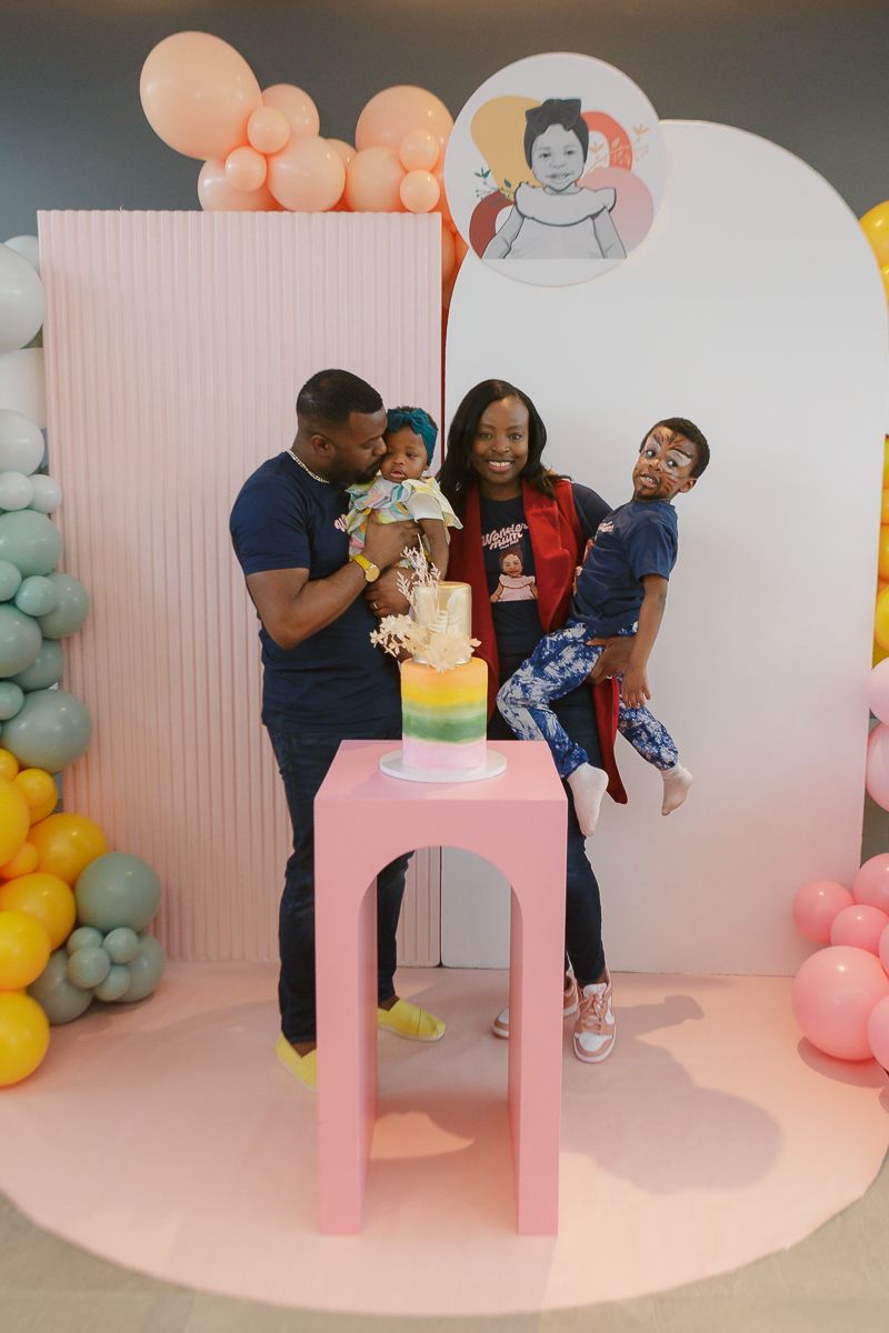 Family portrait by cake with mom, dad, toddler boy, and birthday girl by NYC family photographer Paula Ortiz