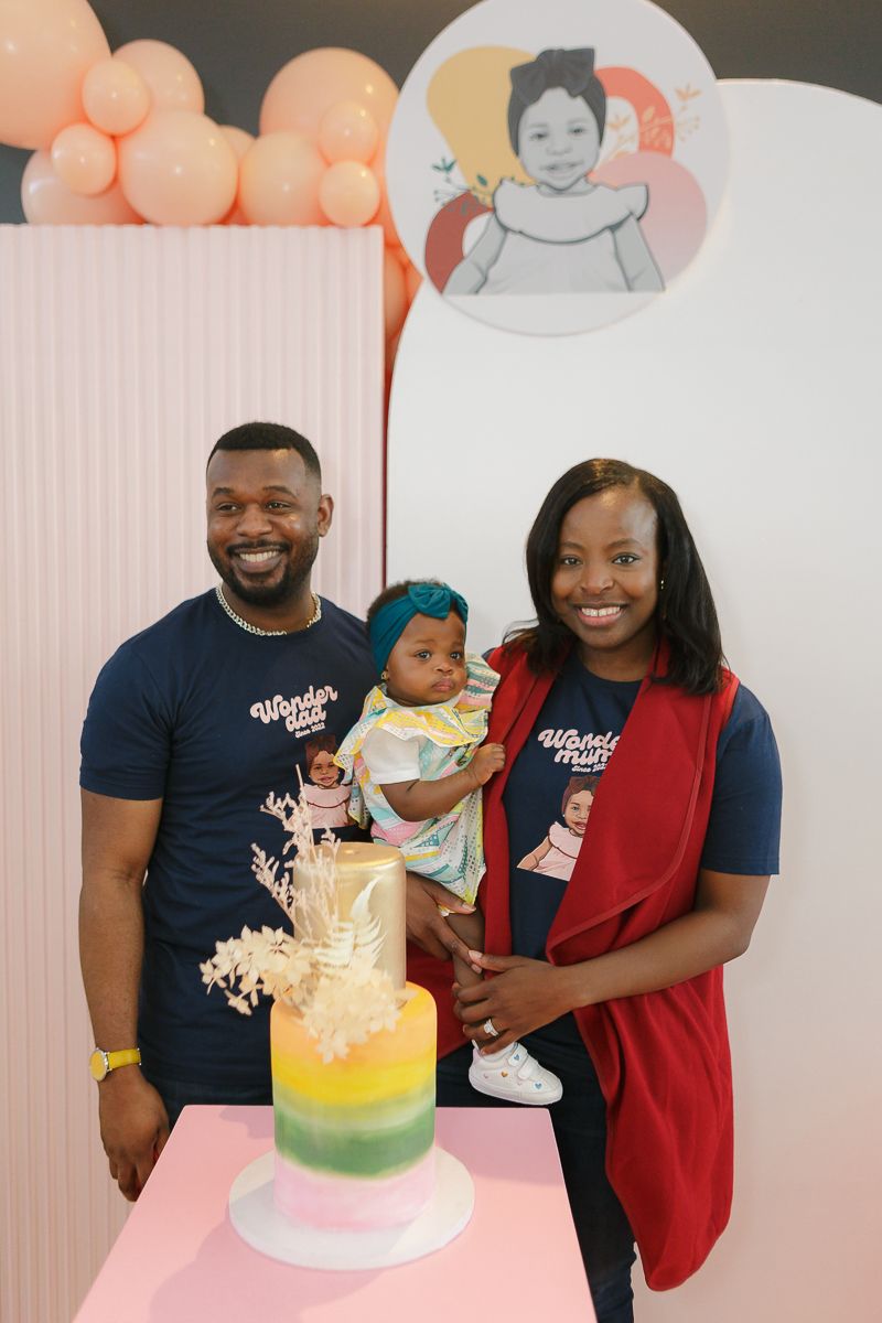 Mom, dad, and birthday girl by cake by NYC family photographer Paula Ortiz