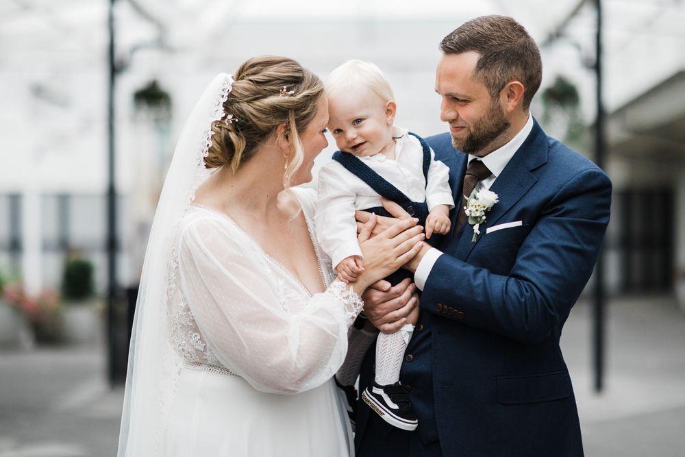 Sweet family embrace captured during wedding celebration in bright indoor setting.