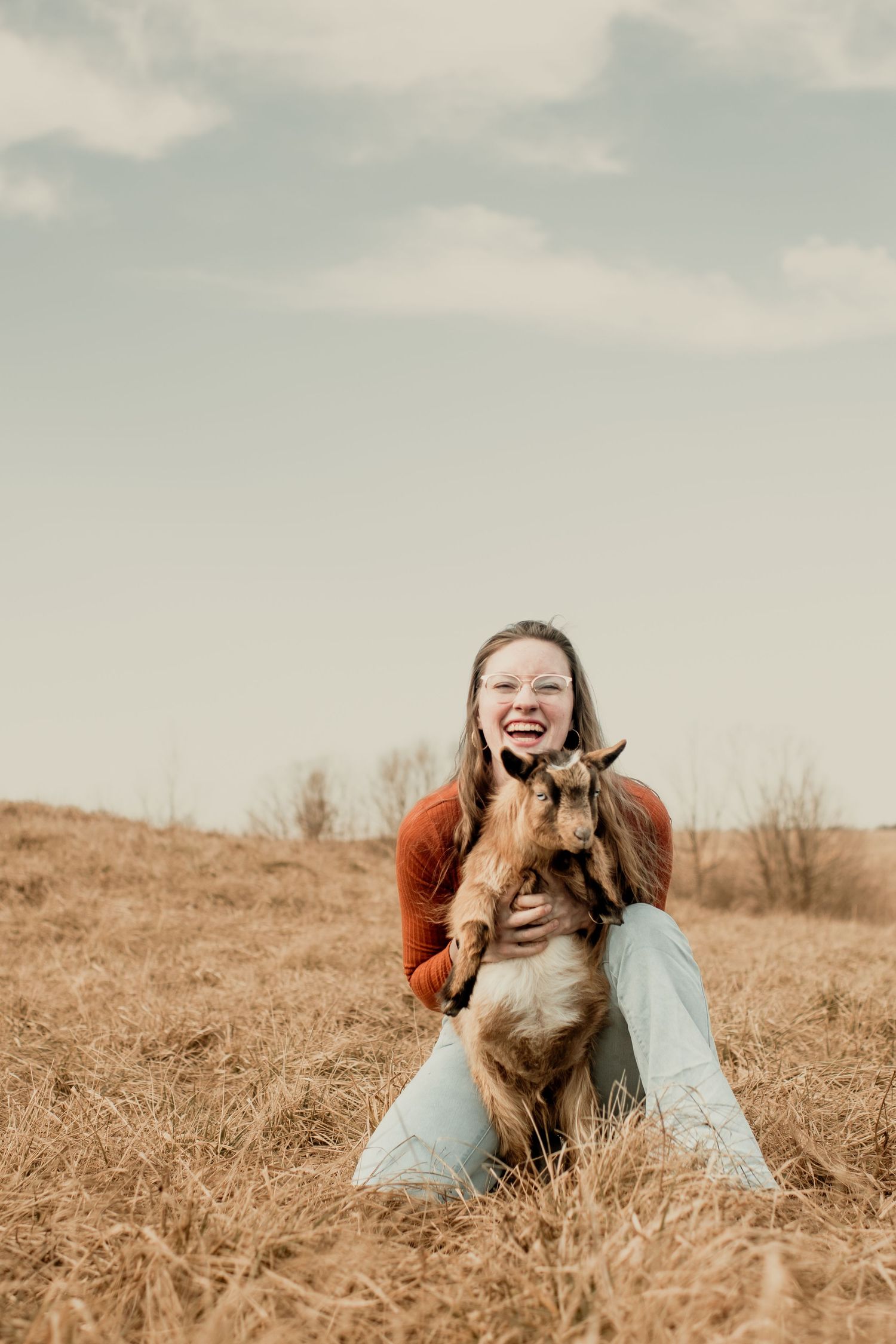 Girl laughing holding her goat