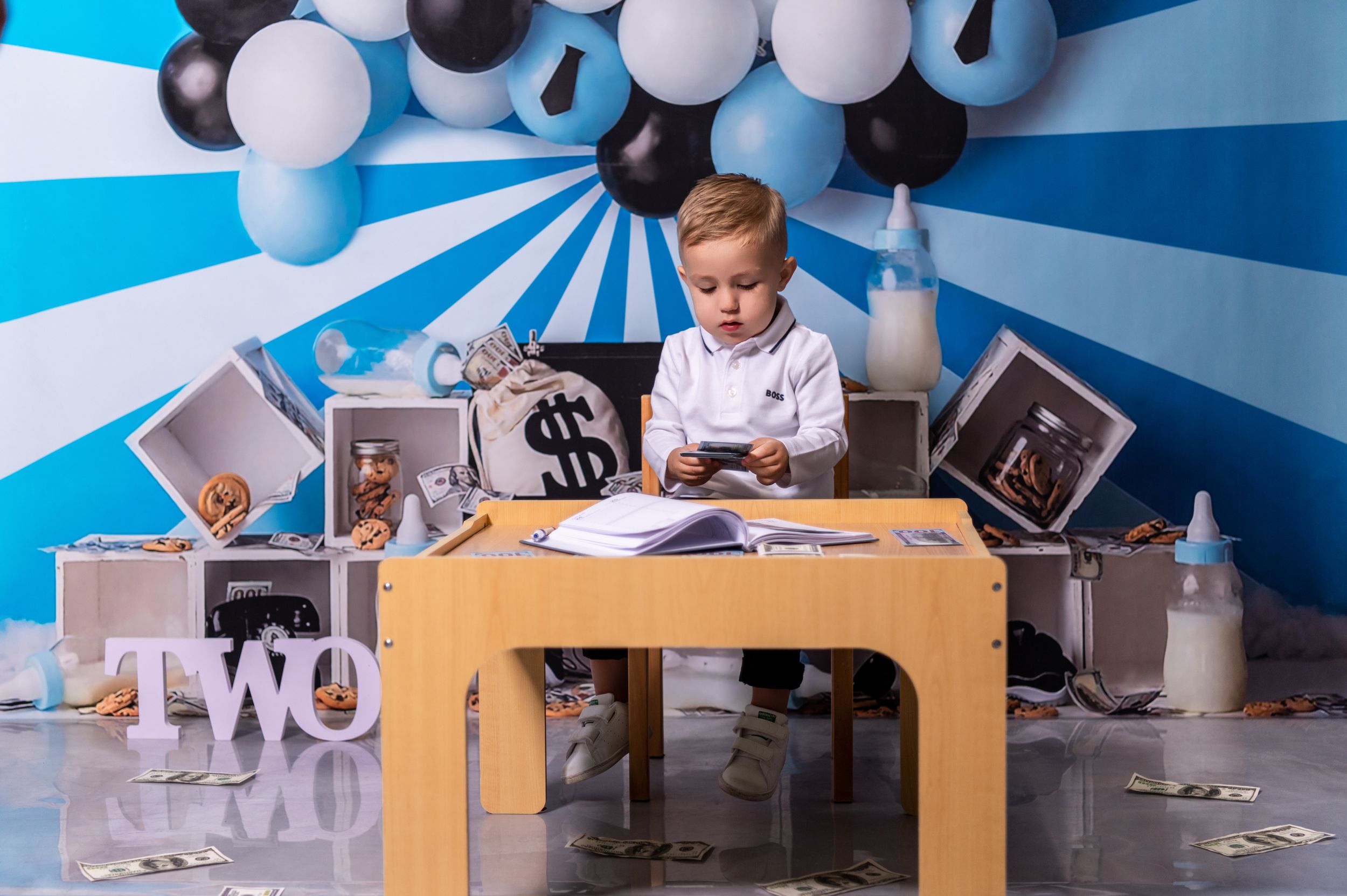 Modern birthday photo setup with blue and white balloons and gold TWO sign.