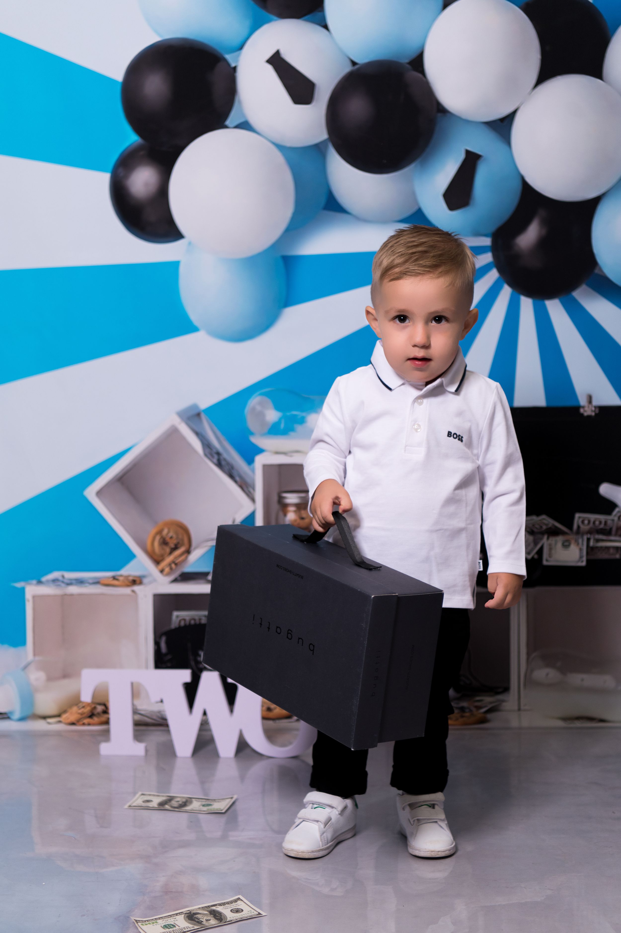Birthday photo setup with blue and black balloons featuring white block letters.