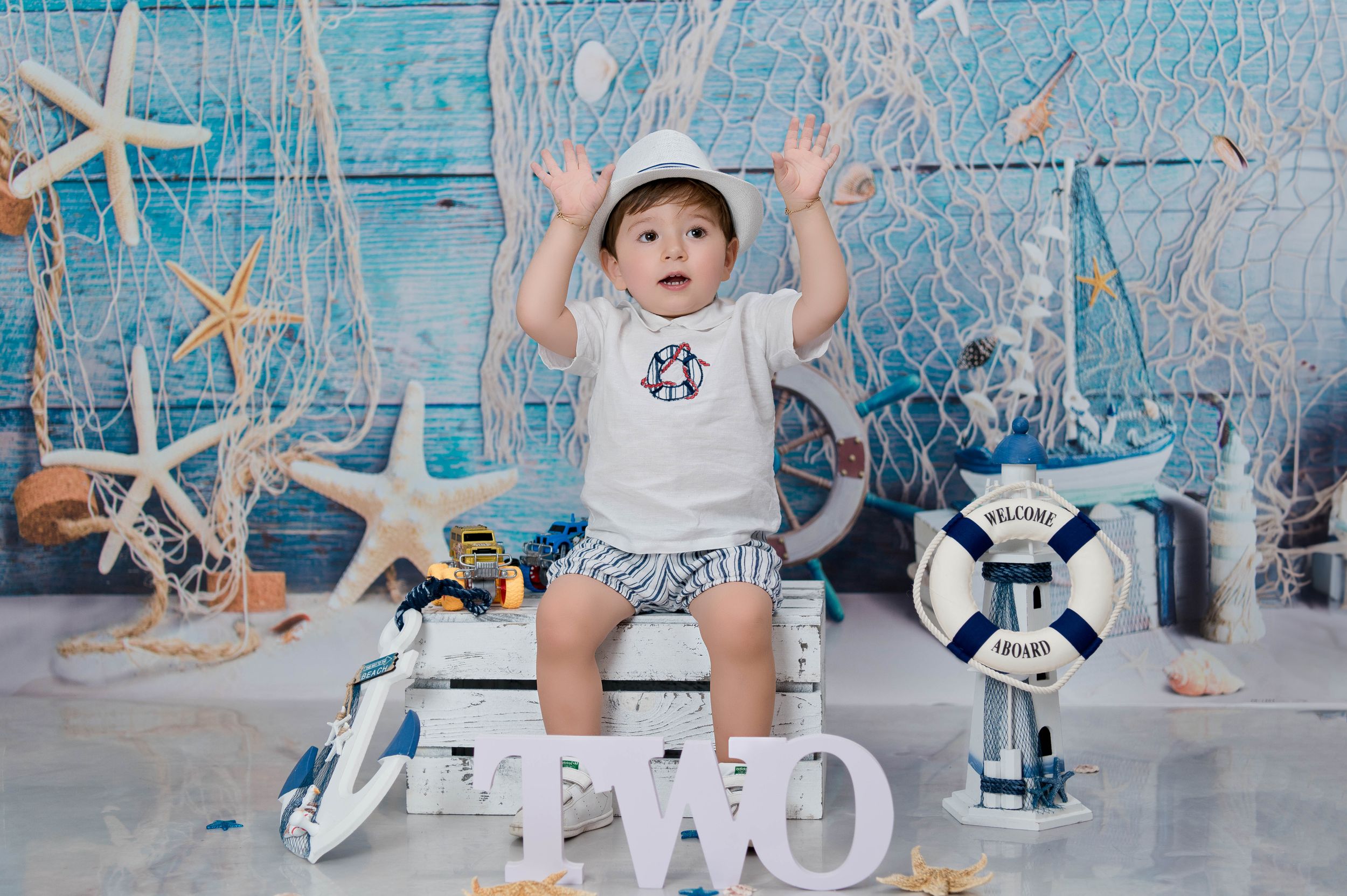 Coastal themed photo setup with TWO letters, starfish, and nautical decorations.