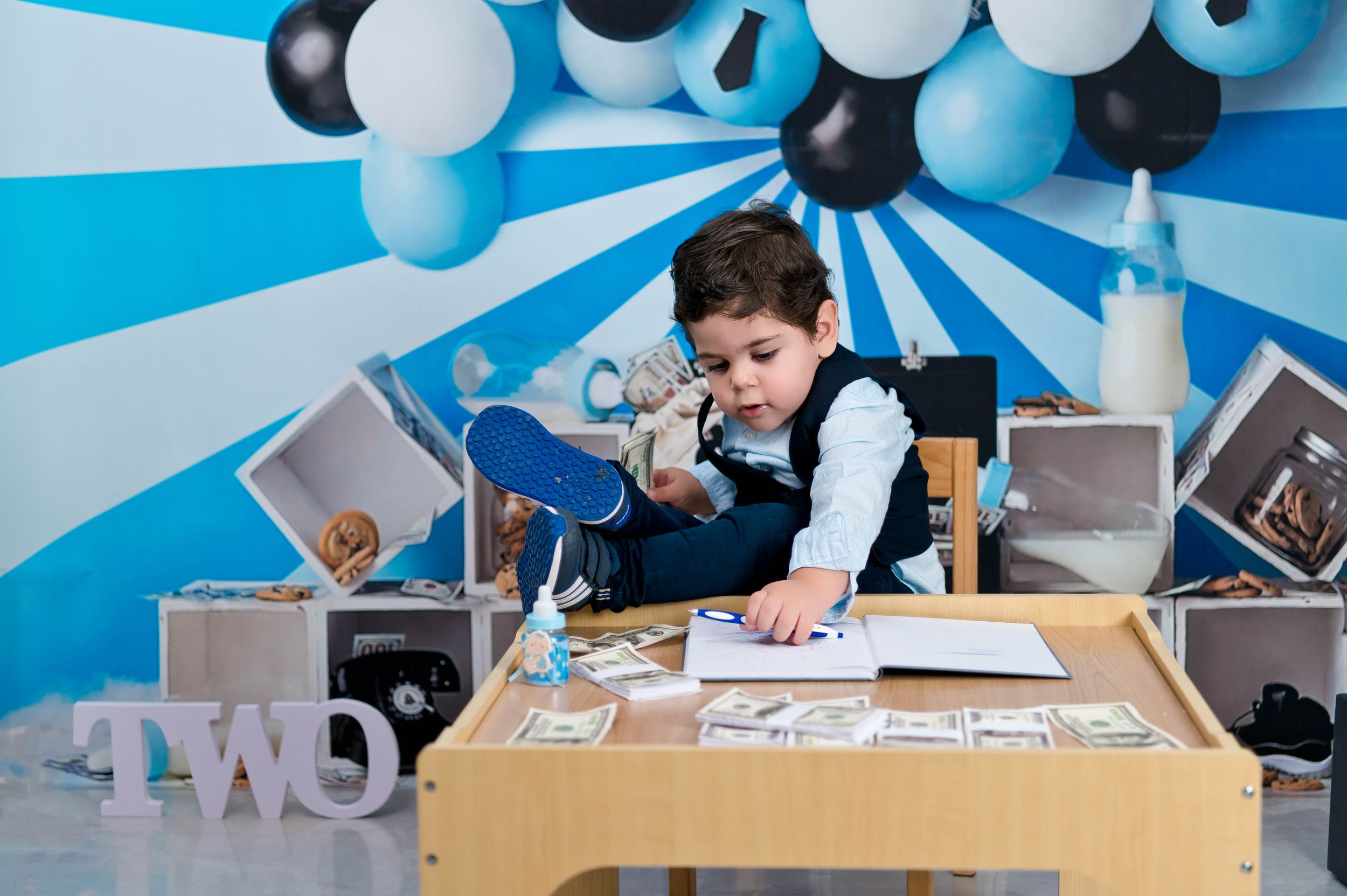 Blue and white balloon backdrop with desk setup and TWO letters decoration.
