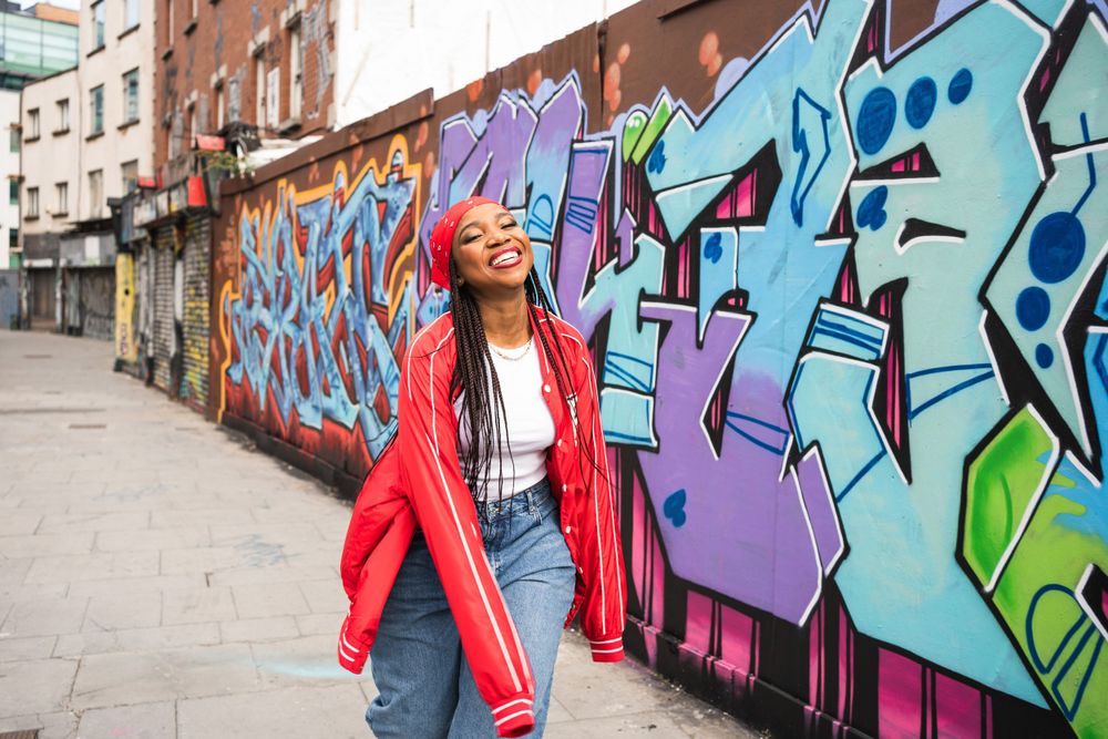black girl on hiphop clothes laughing and dancing at dublin streets