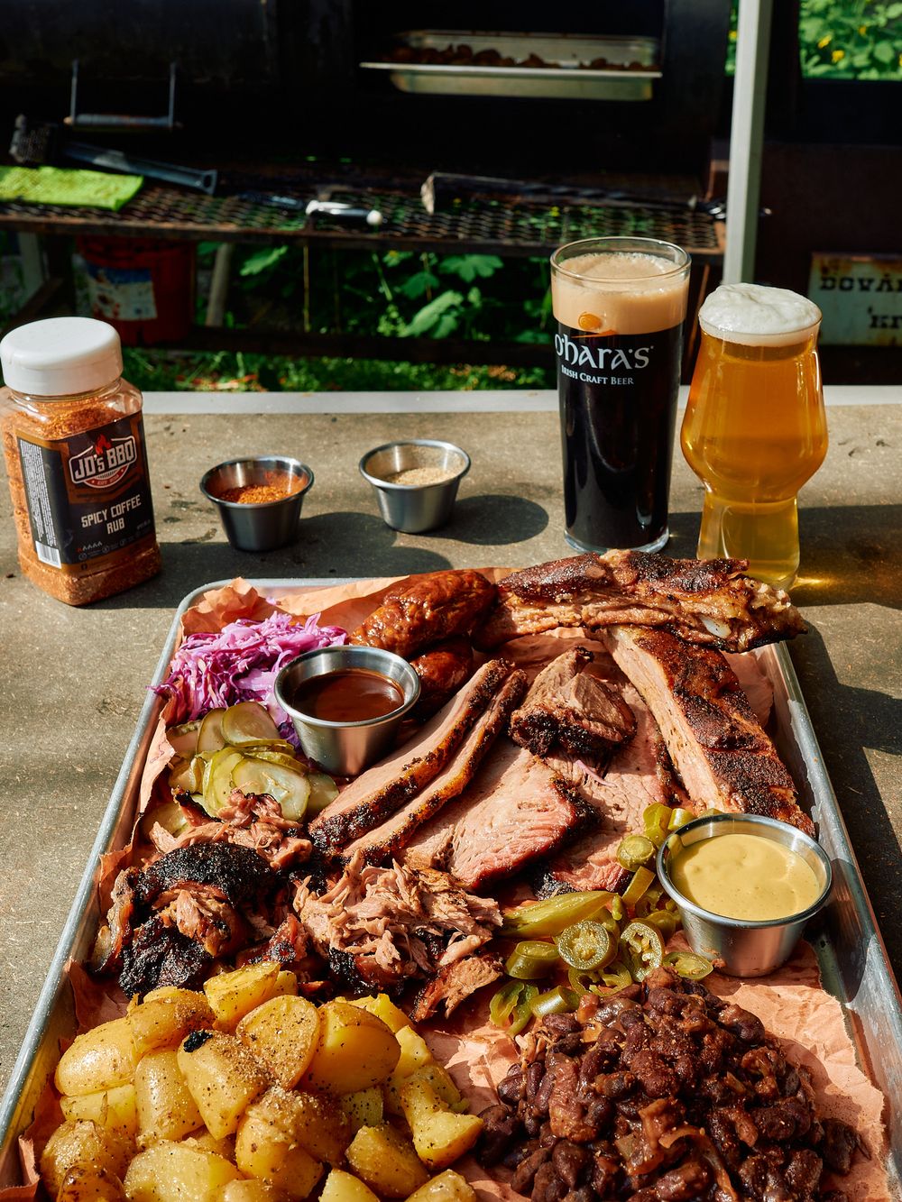 BBQ platter with smoked meats, potatoes, sauces and craft beers.