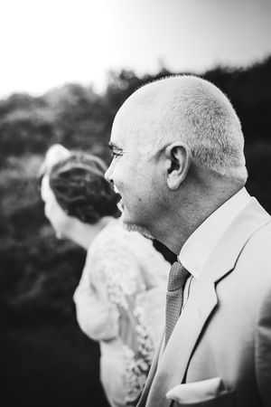 Black and white profile portrait during an outdoor wedding celebration.