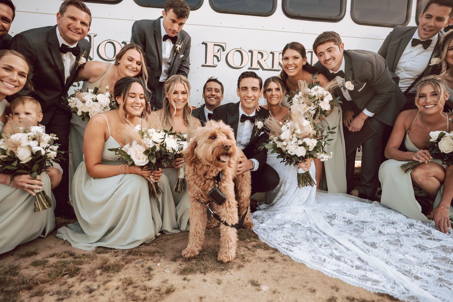 A fun wedding party crouching down to take photo with the ring bearer at Camp Hero in Montauk