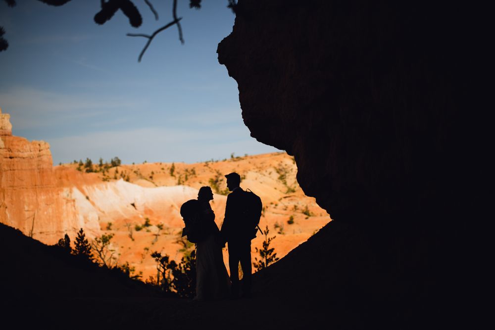 Couple silhouetted with backpacks on at Bryce Canyon National Park.