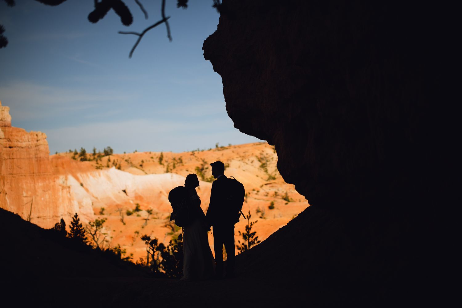 Couple silhouetted with backpacks on at Bryce Canyon National Park.