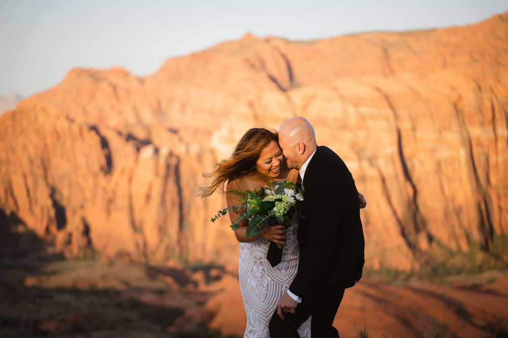 Couple laughing on their wedding day at sunrise in Snow Canyon State Park.