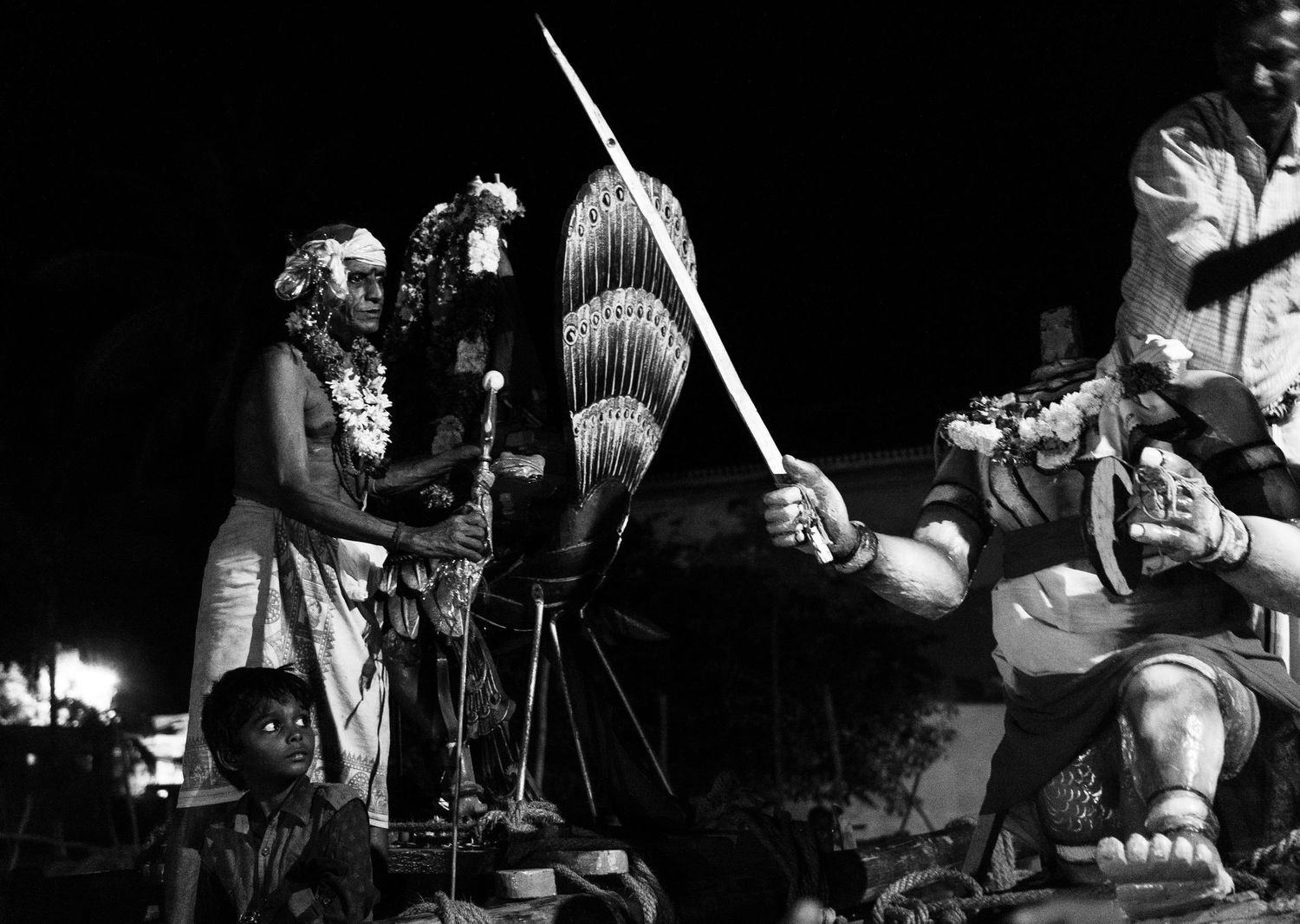 Cultural performers demonstrate traditional Hawaiian ceremonies with spears and kahili standards.