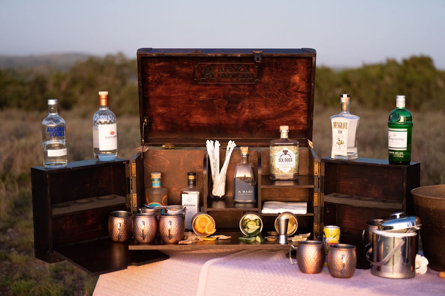 Rustic wooden bar setup with various bottles and cocktail supplies.