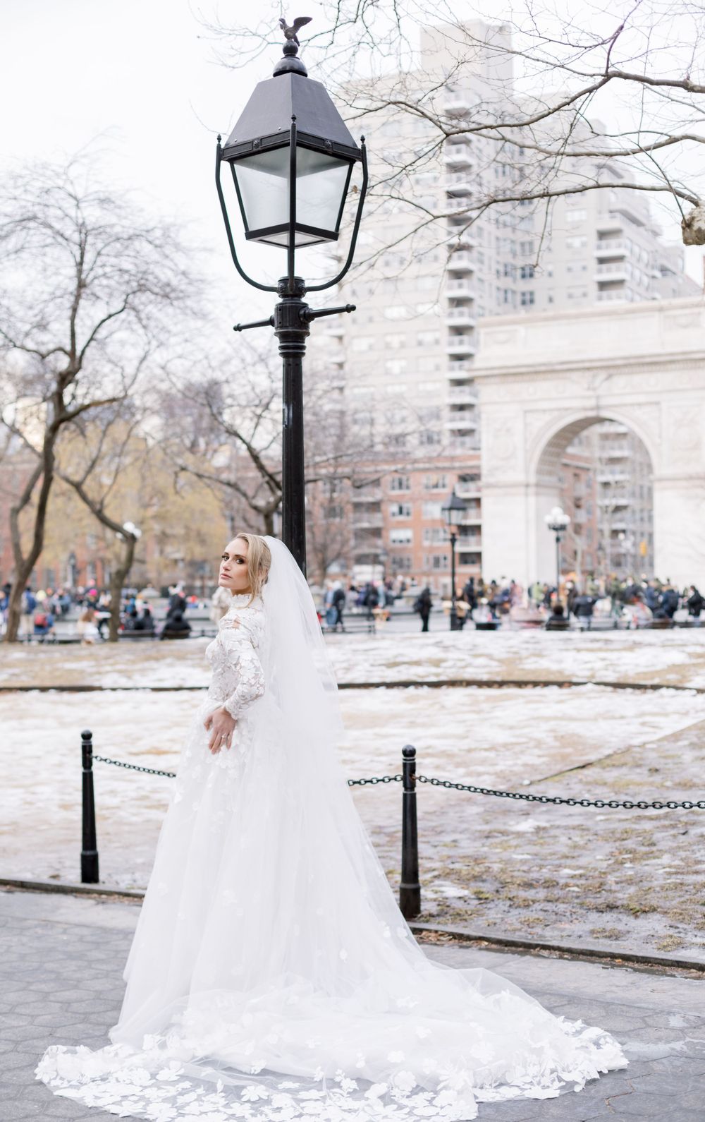 Winter bridal portrait near Washington Square Arch with vintage lamppost and long train.