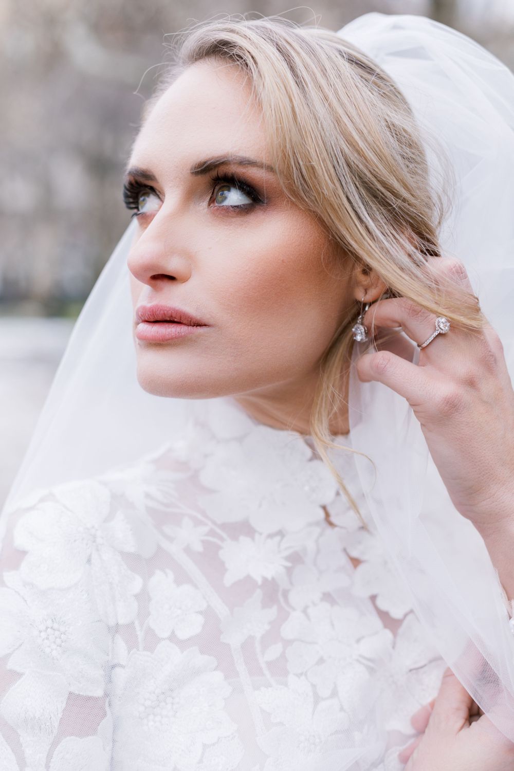 Close-up bridal portrait featuring delicate lace details and a sheer veil in natural lighting.
