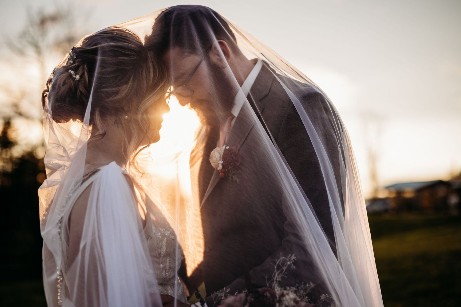 Bride and groom under a veil at sunset in Philippi, WV.