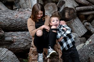 sibling photo with wood pile being silly