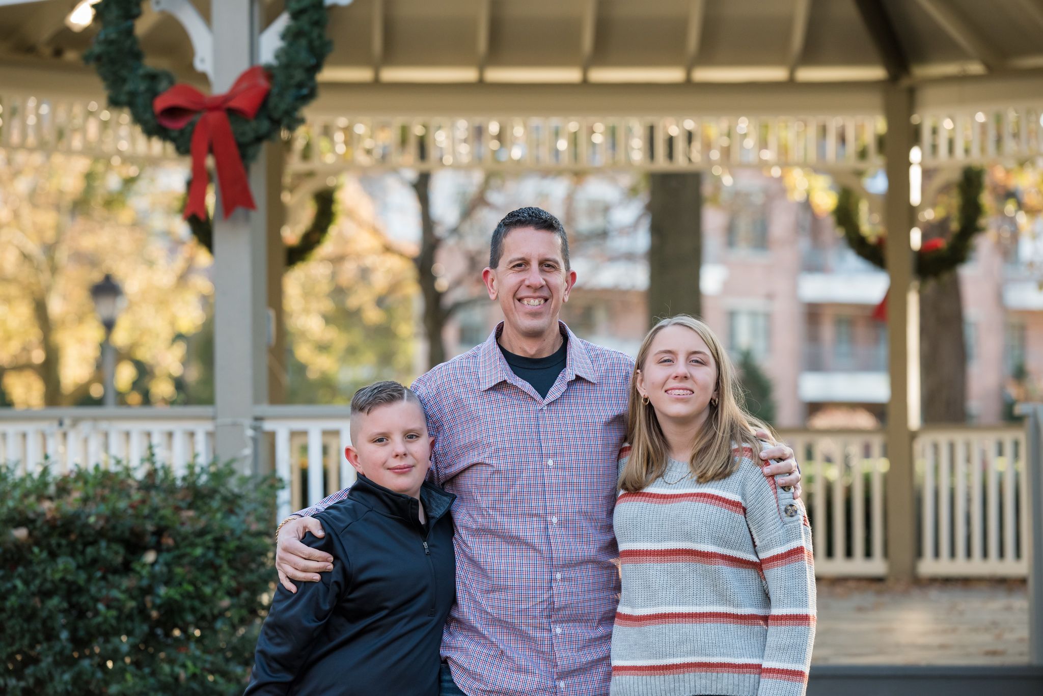 Christmas picture of dad and kids by gazebo