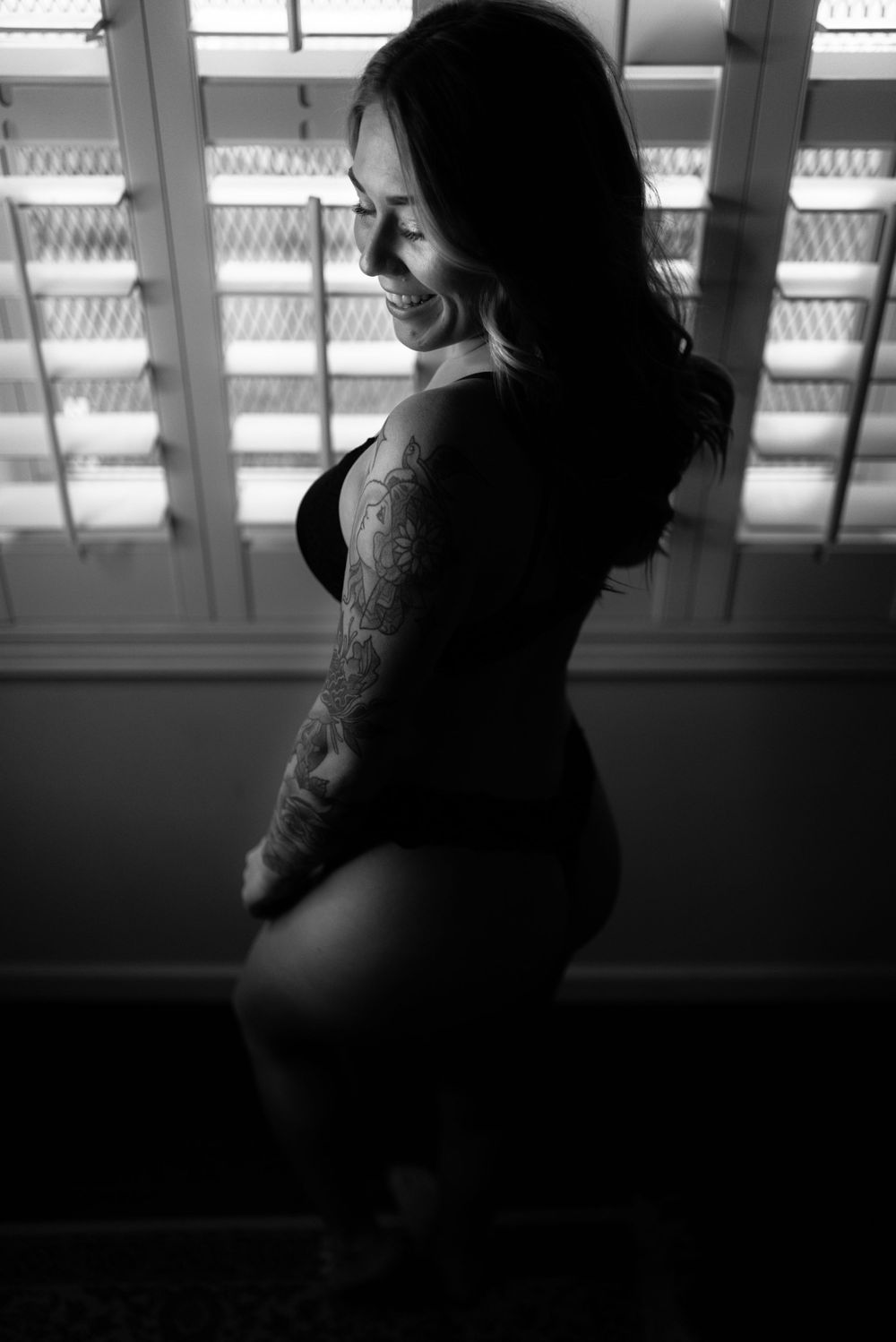 Silhouetted profile of a woman in intimate attire against window light.