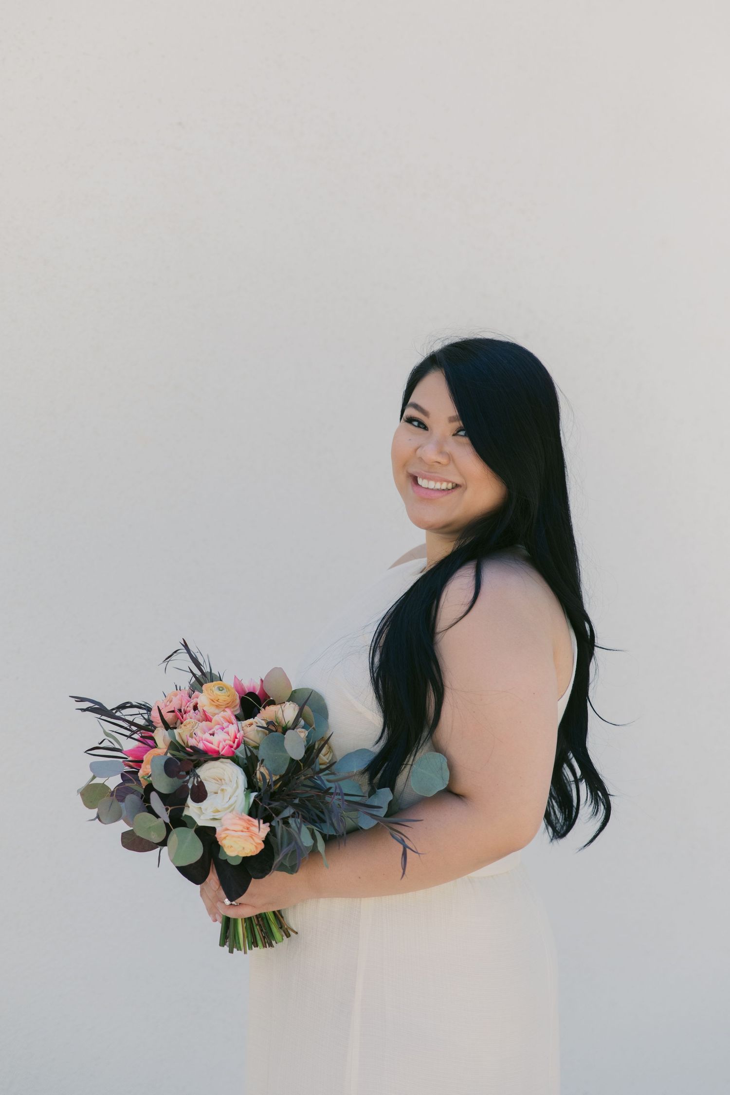 Candid bridal portraits showcase joyful moments with a stunning floral bouquet.
