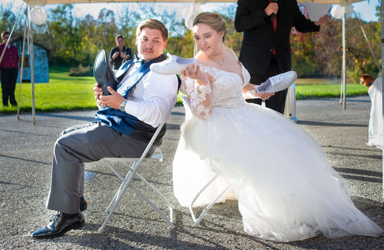 Playful wedding couple sitting in chairs outdoors for a fun photo opportunity.