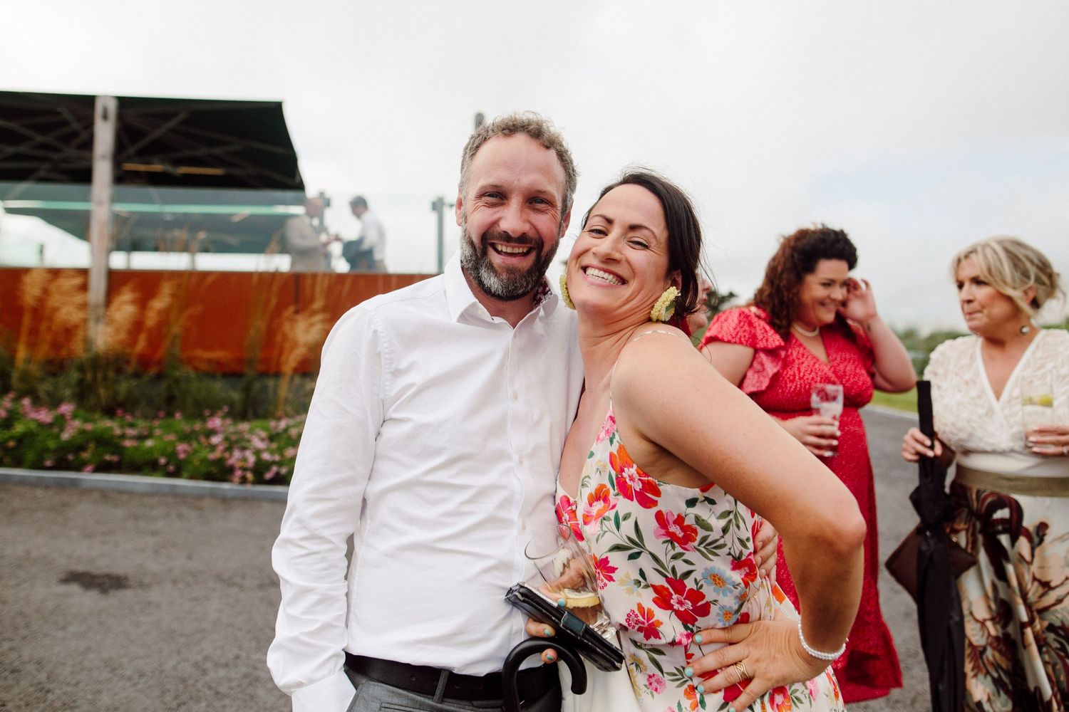 A joyful couple shares a candid laughing moment at an outdoor wedding reception.