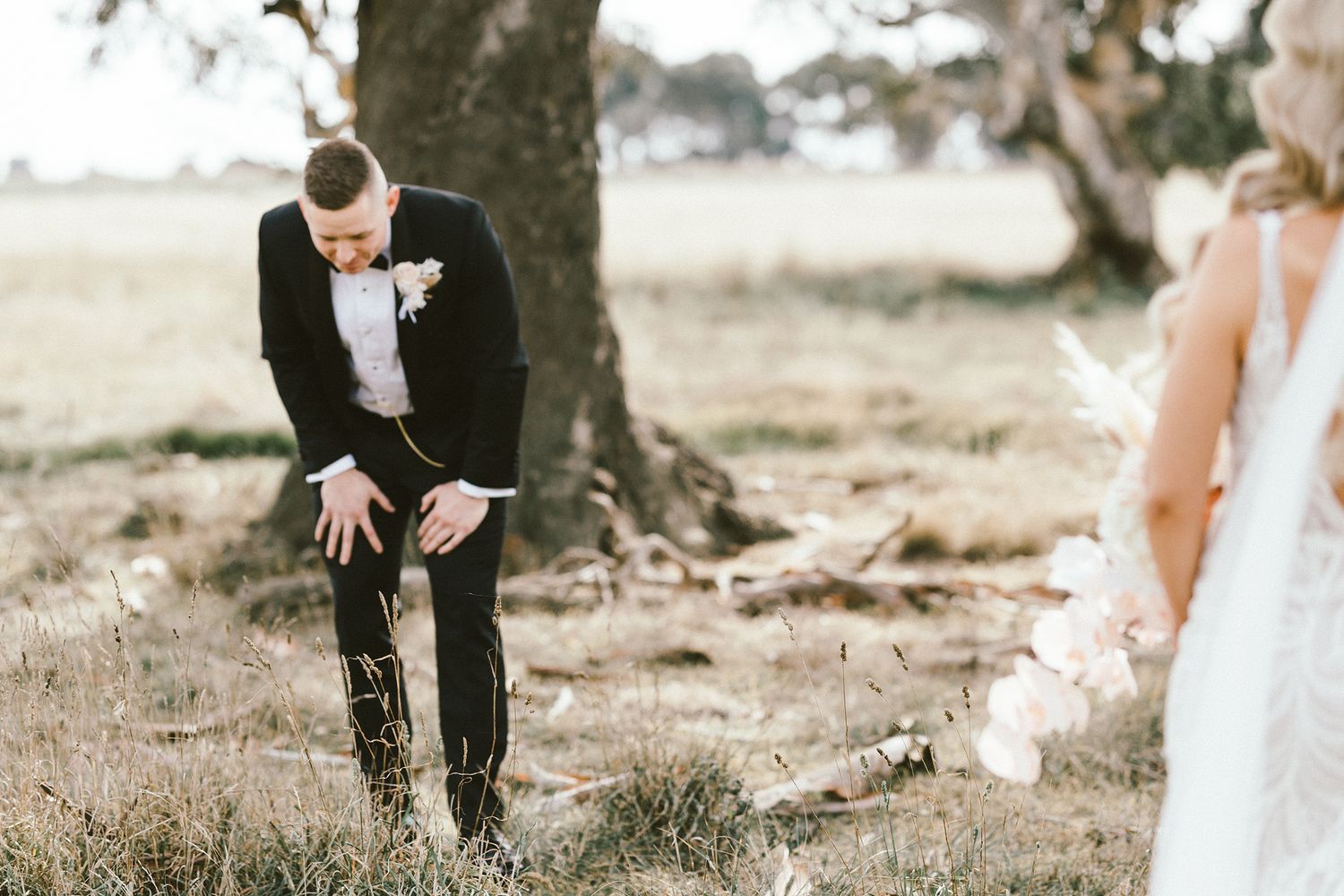 An emotional wedding moment captured under a towering gum tree.