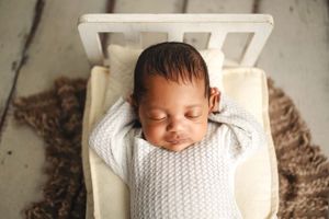 newborn baby laying in bed