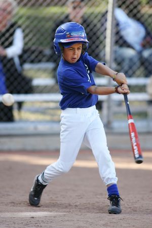 Youth baseball player in Dodgers uniform takes batting stance at home plate.