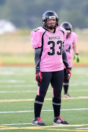 Football player in pink Marysville jersey number 33 standing on the field.