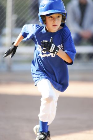 Baseball player in blue uniform sprinting on baseball diamond.
